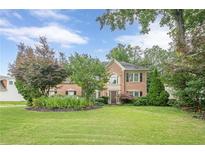 Traditional brick home boasting a manicured lawn and mature landscaping at 10865 Glenhurst Pass, Duluth, GA 30097