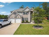 Charming two-story home with a well-manicured lawn, a spacious driveway, and a two-car garage at 3796 Village Crossing Ln, Ellenwood, GA 30294