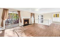 Bright living room features a fireplace, wood floors and access to an outdoor deck at 1482 N Crossing N Cir, Atlanta, GA 30329