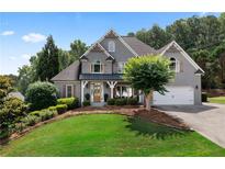 Beautiful, light grey brick home featuring manicured lawn, mature landscaping, and attached two car garage at 1254 Hadaway Garden Nw Dr, Kennesaw, GA 30152