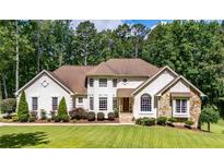 Stately two-story home boasts a manicured lawn and a stone and stucco facade at 6945 John Rivers Rd, Fairburn, GA 30213