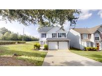 Charming two-story home featuring a two-car garage, neutral siding, and well-maintained landscaping at 1001 Balsam Wood Trl, Villa Rica, GA 30180