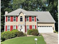 Charming two-story home featuring a well-manicured lawn, bright red shutters, and an attached two-car garage at 1019 Wolf Springs Ct, Lawrenceville, GA 30043