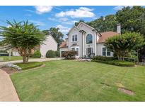 Charming two-story home featuring a manicured lawn and well-maintained landscaping at 1430 Grovehurst Dr, Marietta, GA 30062