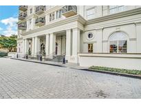 Elegant building entrance with stately columns and a well-maintained brick drive-up providing a sophisticated arrival experience at 195 14Th St # 902, Atlanta, GA 30309
