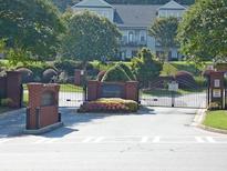 Gated entrance to Brookside Green featuring mature trees, professional landscaping and brick pillars at 5933 Brookside Oak Cir, Norcross, GA 30093