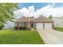 Charming single-story brick home featuring a well-manicured lawn and a two-car garage at 2895 Dominion Walk Ln, Snellville, GA 30078