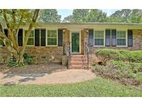 Charming brick home featuring dark shutters and mature landscaping around the front entrance at 501 Bridlepath Ln, Peachtree City, GA 30269