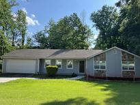 Charming single-story home featuring stone accents and a well-maintained front lawn at 1701 Charmeth Rd, Lithonia, GA 30058