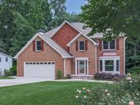 Traditional two-story brick home with a well-manicured lawn, mature trees and an attached two-car garage at 4271 Edgewater Drive Northwest Nw Dr, Kennesaw, GA 30144