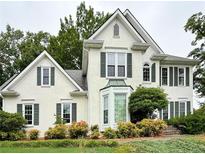 Charming two-story house with stucco siding, a manicured lawn, and lush landscaping at 4715 Scotney Ct, Suwanee, GA 30024