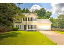 Charming two-story home with a well-manicured lawn and a two-car garage at 8690 Cedar Creek Rdg, Riverdale, GA 30274