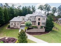 Stunning stone home boasts mature trees, lush landscaping, and a private driveway at 9695 Almaviva Dr, Alpharetta, GA 30022