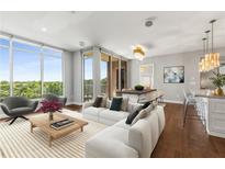 Bright living room with large windows, modern furniture, and access to a balcony showcasing the beautiful outdoor view at 1820 Peachtree Nw St # 804, Atlanta, GA 30309
