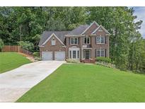 Beautiful two-story brick home featuring an attached two-car garage and a well-manicured front lawn at 2045 Barrett Downs Dr, Cumming, GA 30040