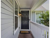 Charming home entrance with a classic black door, decorative light fixture, and welcoming porch at 907 Olde Mill Ln, Norcross, GA 30093