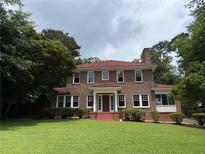 Beautiful two-story brick home featuring a well-maintained lawn and a charming red tile roof at 1098 Oakdale Ne Rd, Atlanta, GA 30307