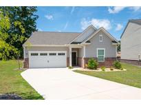 Charming single-story home with a two-car garage and a well-manicured lawn at 7301 Cranleigh St, Covington, GA 30014