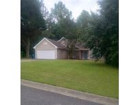 Charming single-story home features a spacious front yard, attached two-car garage, and traditional architectural details at 2868 Evonshire Ln, Dacula, GA 30019