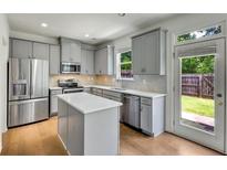 Modern kitchen featuring stainless steel appliances, a center island, and light gray cabinets at 5312 Brooklands Dr, Lithonia, GA 30058