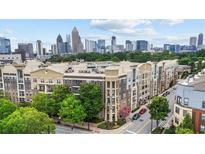 Low-rise apartment building with green trees in front, featuring a stunning cityscape in the background at 390 17Th Nw St # 4031, Atlanta, GA 30363