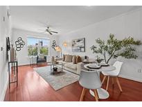 Bright living room features hardwood floors, natural light, a ceiling fan, and modern decor at 390 17Th Nw St # 4031, Atlanta, GA 30363