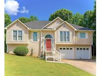Charming two-story home featuring a red front door, two-car garage, and well-maintained landscaping at 507 Legacy Park Ln, Powder Springs, GA 30127