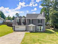 Charming two-story home featuring a two-car garage, manicured lawn, and classic architectural details at 625 Hickory Nobb, Sugar Hill, GA 30518