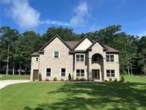 Beautiful two-story brick home featuring a manicured lawn and traditional design elements at 2571 Se Ebenezer Rd, Conyers, GA 30094