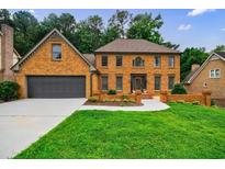 Charming brick home with a well-manicured lawn and a two-car garage at 5826 Andover Way, Tucker, GA 30084