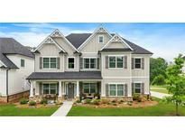 Charming two-story home with manicured lawn and covered front porch with stone accents and neutral-colored siding at 2326 Britt St, Grayson, GA 30017