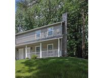 Charming townhome featuring a quaint front porch and beautiful landscaping, perfect for relaxing outdoors at 4520 Coopers Creek Se Cir, Smyrna, GA 30082