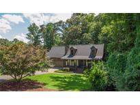 Charming Cape Cod-style home with a manicured lawn and mature trees at 1066 Sea Oats Sw Way, Lilburn, GA 30047
