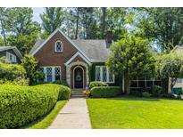 Charming brick home with a well-manicured lawn, lush greenery, and inviting curb appeal at 401 Emory Ne Dr, Atlanta, GA 30307