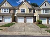 Charming townhome exterior featuring a two-car garage and well-maintained landscaping at 1865 Ellison Lakes Nw Ct # 21, Kennesaw, GA 30152