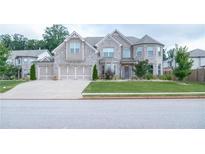 Stunning two-story home with a three-car garage, stone and siding details, and a well-manicured lawn at 3739 In Bloom Way, Auburn, GA 30011