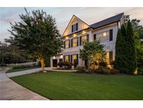 Well-manicured front yard, black shuttered windows and garage on a two-story home at dusk at 1059 Rockford Township Sw Dr, Marietta, GA 30064