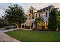 Charming two-story home featuring a lush green lawn, mature landscaping, and classic black shutters at 1059 Rockford Township Sw Dr, Marietta, GA 30064
