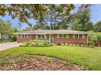 Charming brick home featuring a well-manicured lawn and mature trees, creating a welcoming curb appeal at 4102 Barr Cir, Tucker, GA 30084