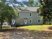 Inviting two-story home with a gray exterior, complemented by stone accents and a well-maintained lawn at 841 N North Price Rd, Sugar Hill, GA 30518