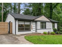 Charming renovated brick home featuring modern windows, stylish front door, and a well-manicured lawn at 1719 San Gabriel Ave, Decatur, GA 30032