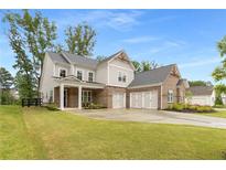 Beautiful two-story home featuring a brick and siding exterior, a three-car garage, and a well-manicured lawn at 4960 Iris St, Cumming, GA 30040