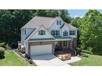 Charming two-story home featuring a well-maintained lawn and a large attached two car garage at 6765 Creek View Ln, Cumming, GA 30041