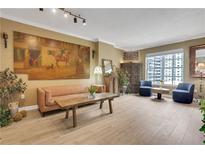 Bright living room with wood-style flooring, large painting, and comfortable seating at 1101 Juniper Ne St # 922, Atlanta, GA 30309