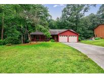 Charming single-story home with a well-manicured lawn, a long driveway, and a two-car garage at 335 Whisper Way, Dacula, GA 30019