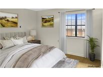 A bedroom featuring a comfortable bed, artwork, and a window with natural light at 475 Mount Vernon Ne Hwy # C230, Sandy Springs, GA 30328