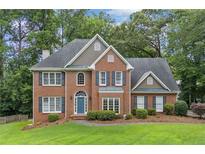 Charming brick home featuring a manicured lawn, blue front door, and classic architectural details at 992 Marbury Sw Ct, Marietta, GA 30064