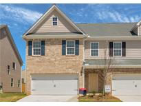 Charming two-story townhome featuring a brick facade, attached garage, and well-maintained landscaping at 2861 Fareed, Douglasville, GA 30135