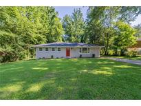 Charming single-story home with lush green lawn and mature trees at 4230 Cheryl Ann Ct, Stone Mountain, GA 30083