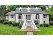 Charming two-story home with symmetrical design, landscaped yard, and double staircase leading to the front entrance at 5105 Vernon Oaks Dr, Dunwoody, GA 30338